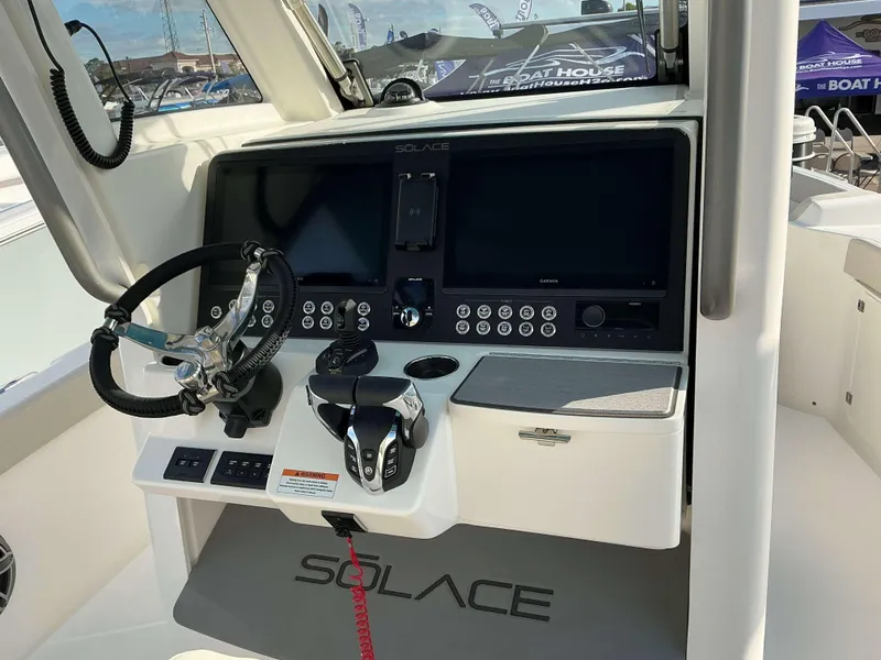Slide: The Image of 2025 Solace 28 HCS boat dashboard with steering wheel and control panel. - 18