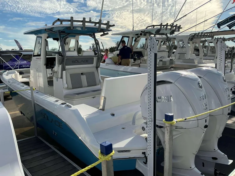 Slide: The Image of 2025 Solace 28 HCS boat with dual Yamaha engines displayed at a marina. - 3