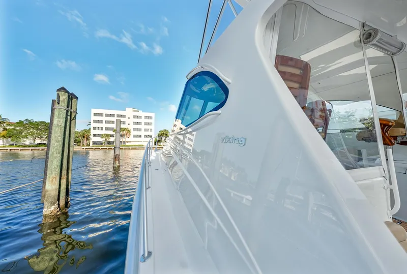 Slide: The Image of 2014 Viking Sport Tower yacht docked by waterfront building under blue sky. - 4