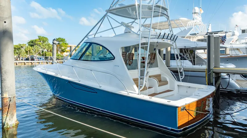Slide: The Image of 2014 Viking Sport Tower yacht docked in marina, featuring sleek design and blue hull. - 5