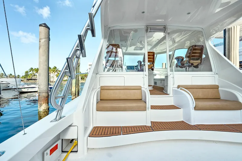 Slide: The Image of 2014 Viking Sport Tower yacht with seating area and helm, docked at marina. - 7