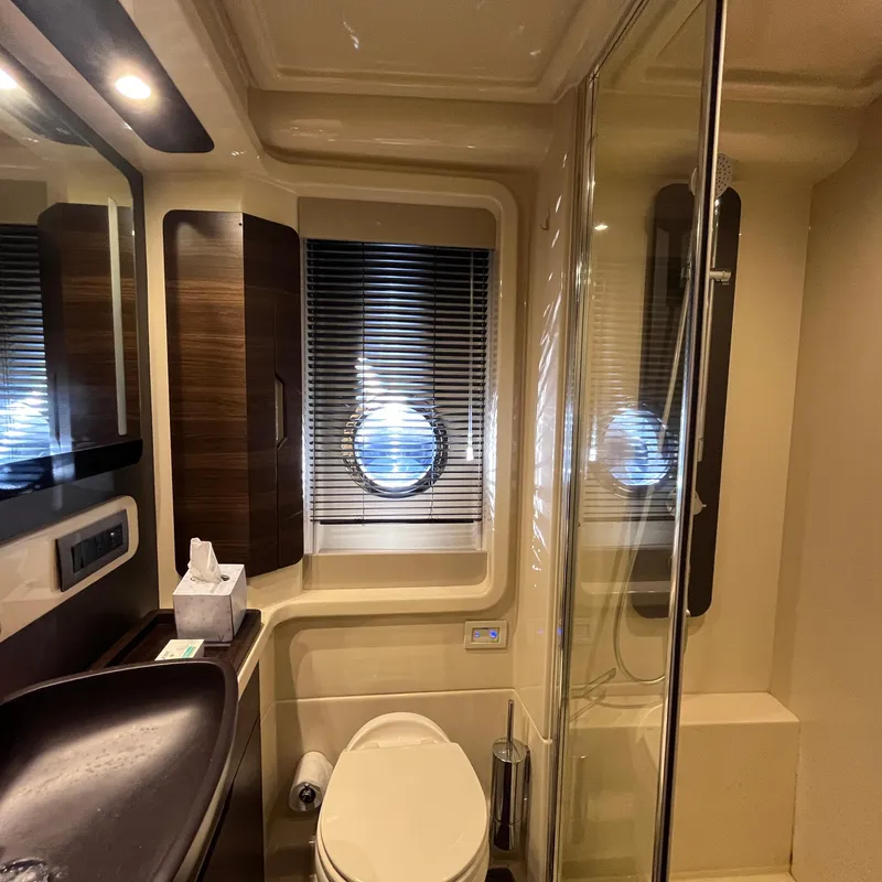 Slide: The Image of Luxurious bathroom in a 2015 Azimut 50 Fly yacht with modern fixtures and porthole window. - 23
