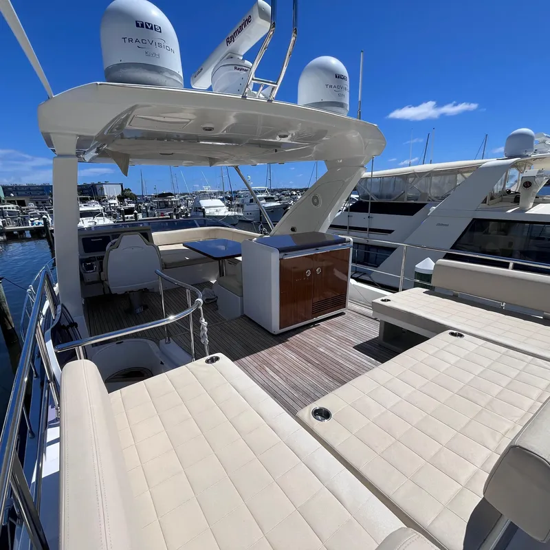 Slide: The Image of Azimut 50 Fly 2015 yacht flybridge with seating, table, and equipment under a clear blue sky. - 26
