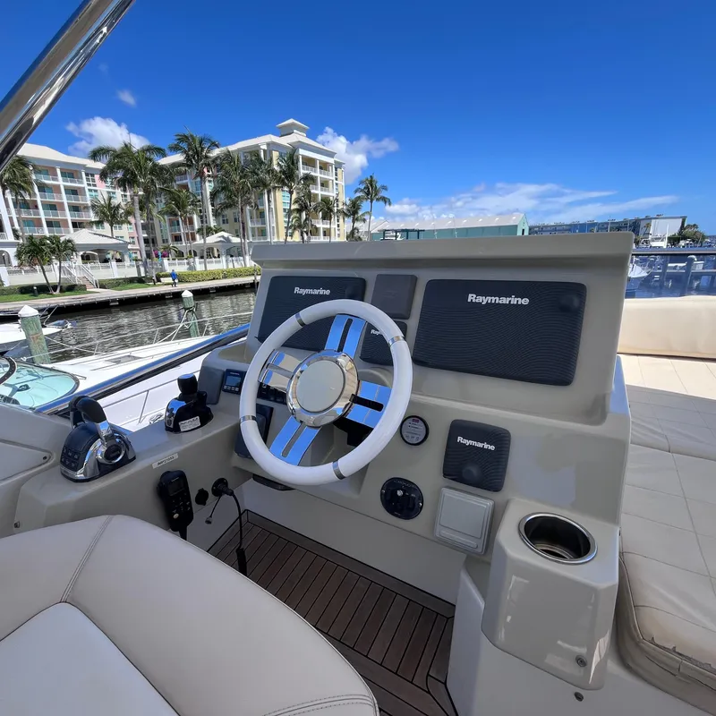 Slide: The Image of Helm of 2015 Azimut 50 Fly yacht with Raymarine equipment, docked near palm trees and buildings. - 30