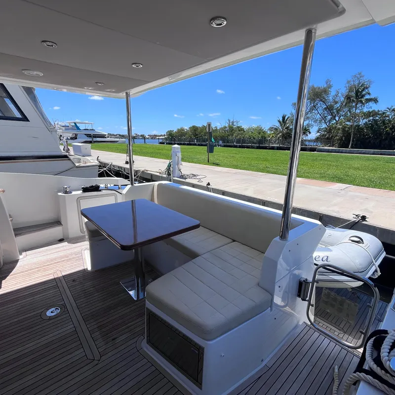 Slide: The Image of Azimut 50 Fly 2015 yacht deck with seating and table, docked by greenery. - 33