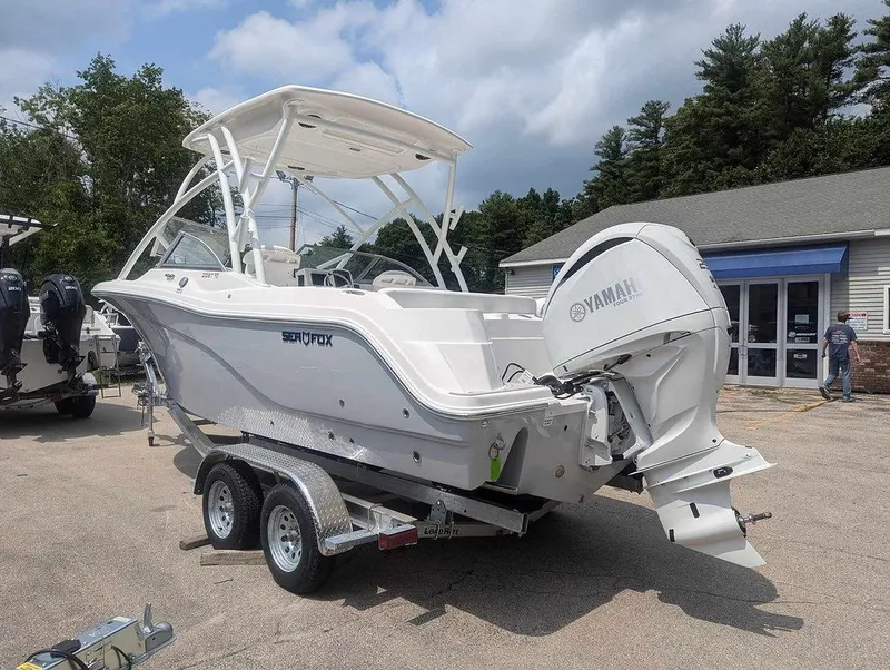 Slide: The Image of 2025 Sea Fox 228 Traveler boat on trailer with Yamaha outboard motor, parked outdoors. - 12