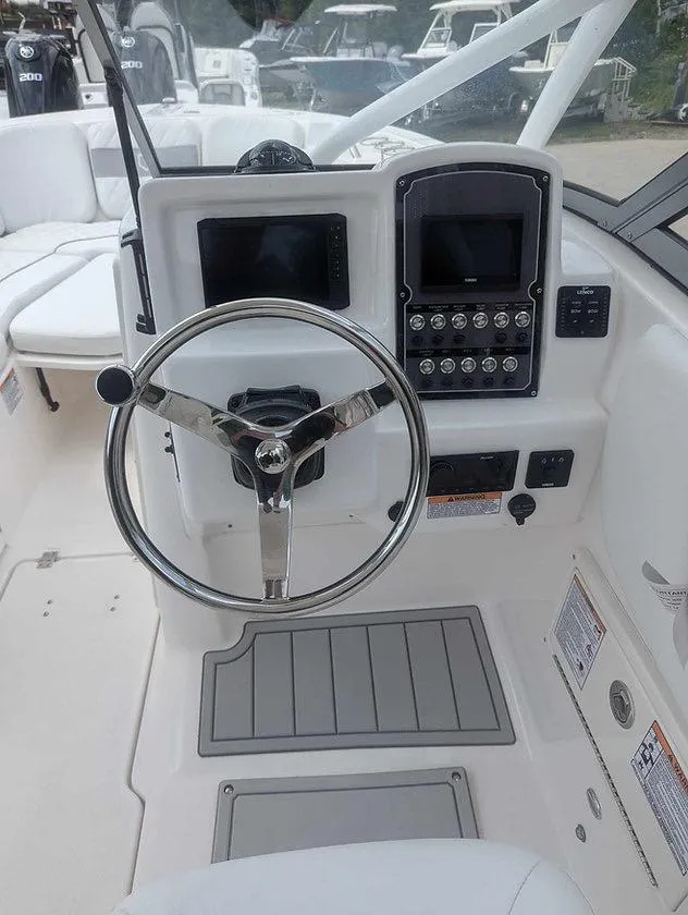 Slide: The Image of 2025 Sea Fox 228 Traveler boat dashboard with steering wheel and control panel. - 6