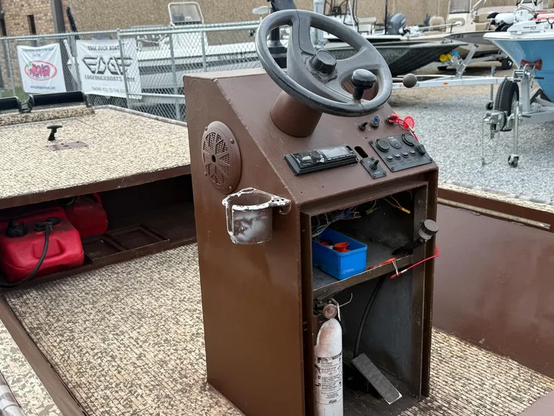 Slide: The Image of 2016 Gator Tail 1648 boat console with steering wheel and controls. - 2