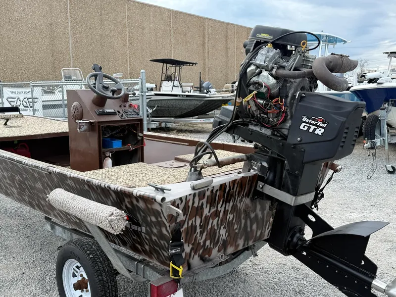 Slide: The Image of 2016 Gator Tail 1648 boat with GTR motor, camo design, on trailer in boatyard. - 4