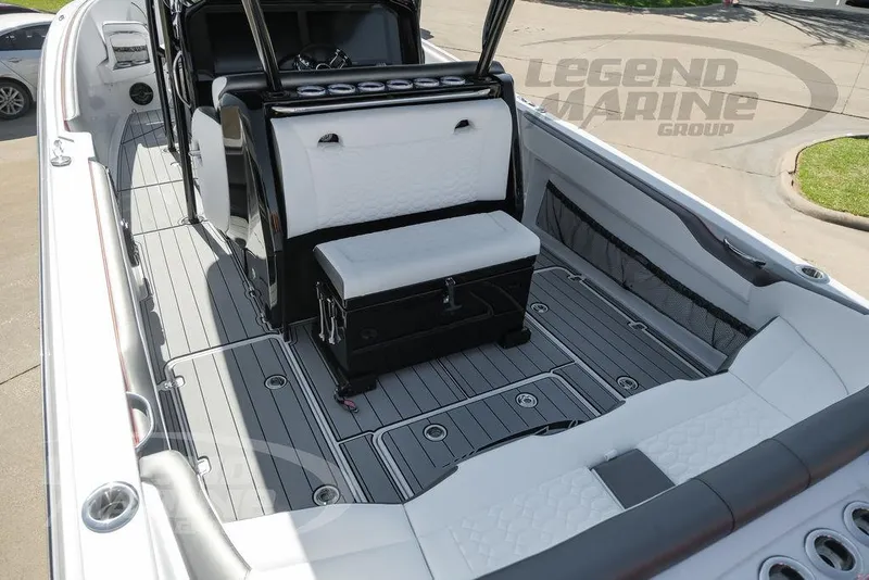 Slide: The Image of 2025 Nor-Tech 340 Sport boat interior with seating and steering wheel, parked in a lot. - 23