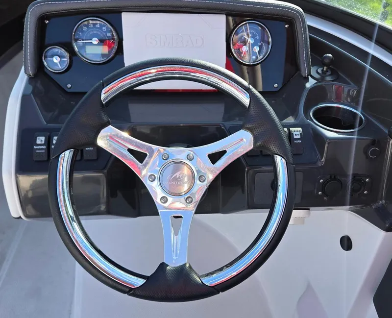 Slide: The Image of Steering wheel and dashboard of 2023 Monterey M225 boat, featuring modern gauges and controls. - 9