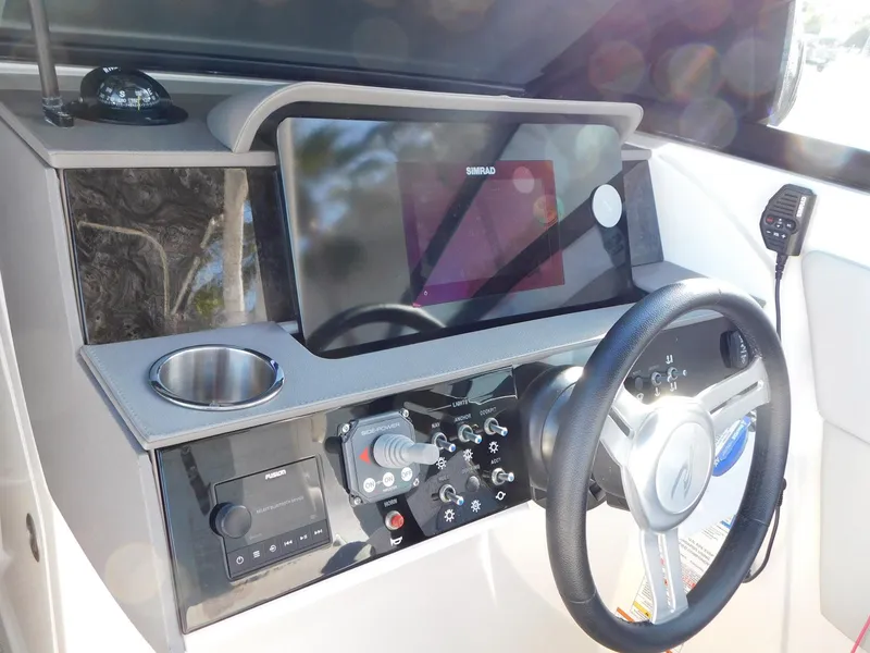 Slide: The Image of 2020 Sea Ray SDX 270 Outboard helm with steering wheel and navigation controls. - 6
