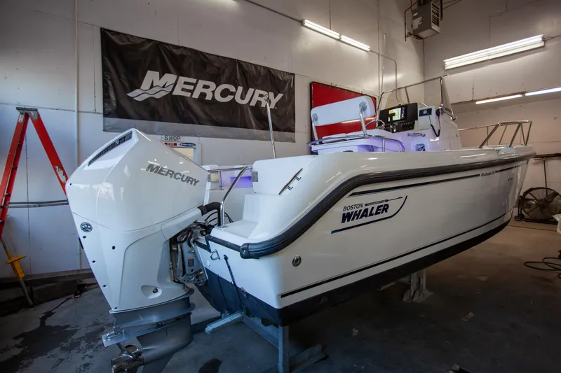 Slide: The Image of Boston Whaler 210 Outrage 2000 model in a workshop with Mercury engine. - 10