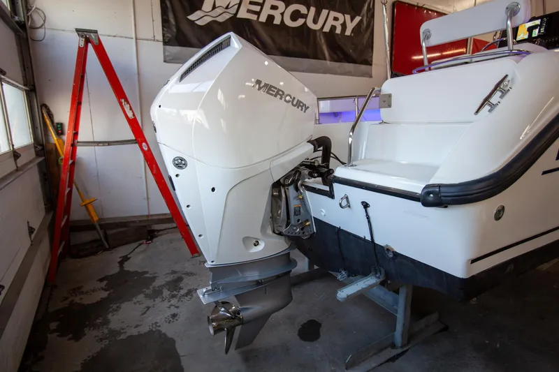 Slide: The Image of Boston Whaler 210 Outrage 2000 with Mercury outboard motor in a garage setting. - 12