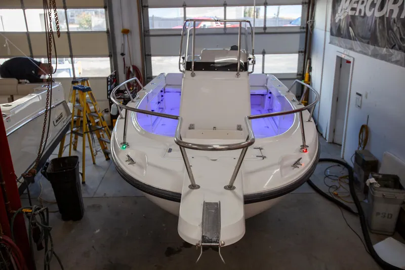 Slide: The Image of 2000 Boston Whaler 210 Outrage boat in a garage with blue interior lighting. - 13