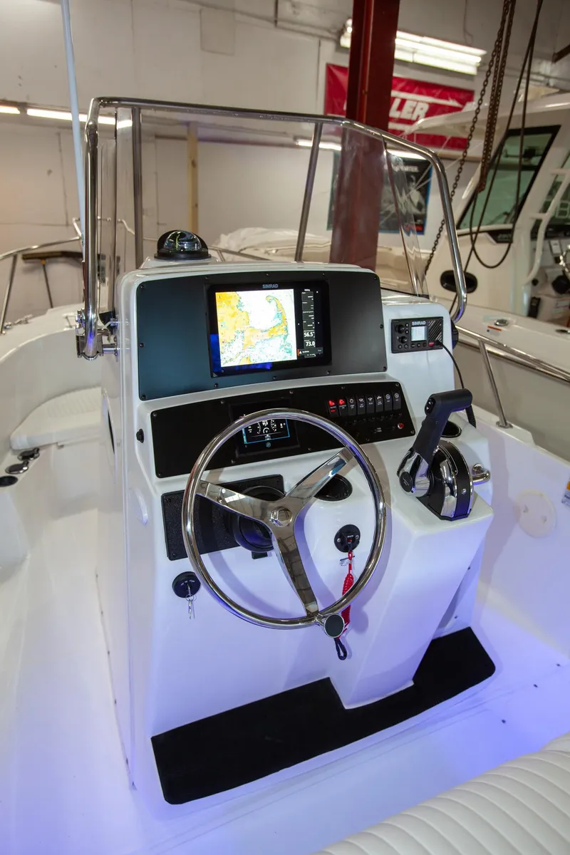 Slide: The Image of Boston Whaler 210 Outrage 2000 model boat console with steering wheel and navigation display. - 4