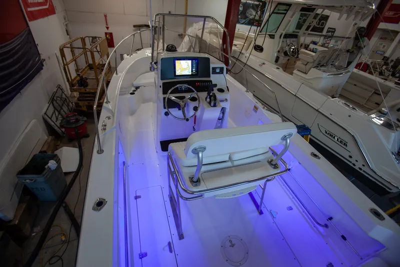 Slide: The Image of 2000 Boston Whaler 210 Outrage boat interior with blue LED lighting in a showroom. - 6