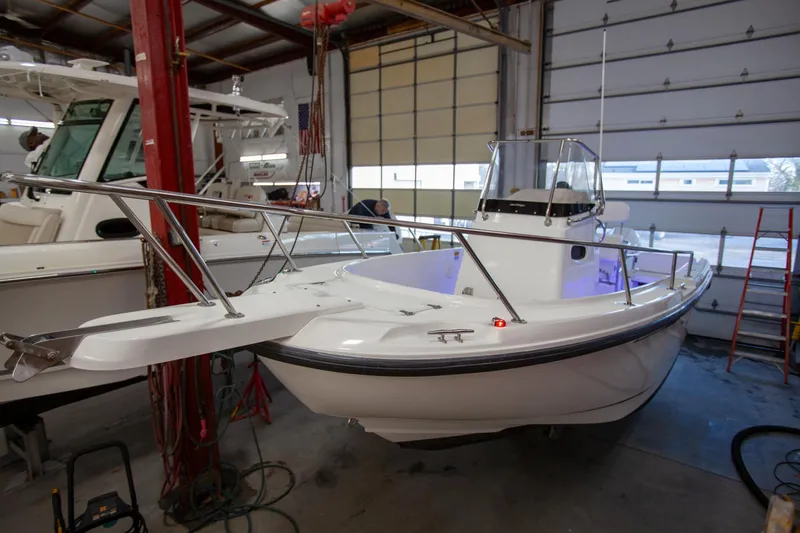 Slide: The Image of Boston Whaler 210 Outrage 2000 model in a garage, showcasing sleek design and sturdy build. - 8