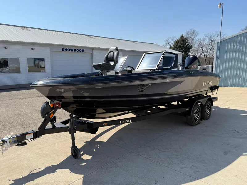 Slide: The Image of 2025 Lund 202 Pro-V GL boat on trailer outside showroom. - 1