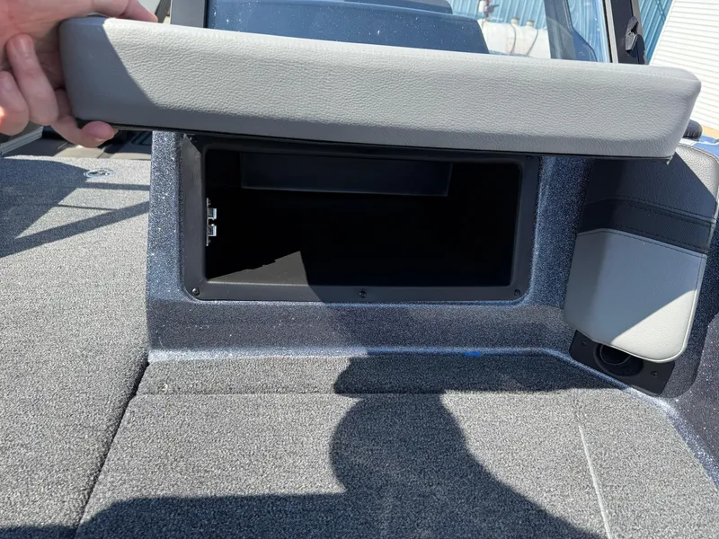 Slide: The Image of 2025 Lund 202 Pro-V GL boat storage compartment with open lid, showcasing interior space. - 11
