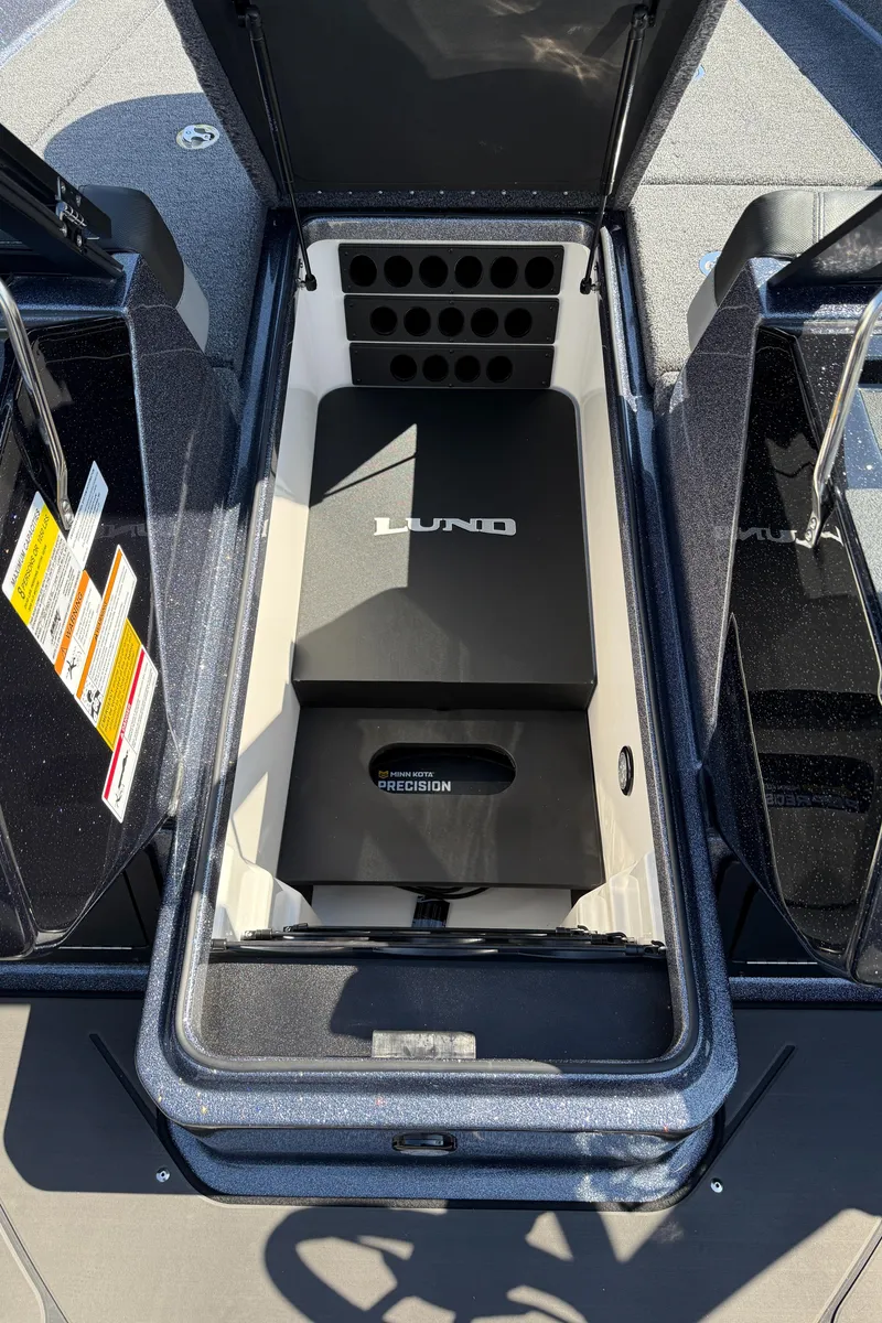 Slide: The Image of 2025 Lund 202 Pro-V GL boat storage compartment with open lid, showcasing organized interior space. - 13