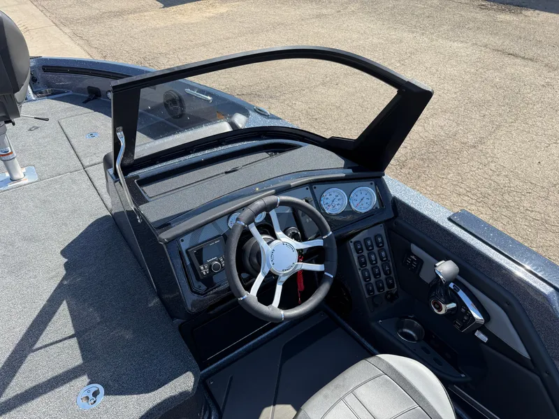 Slide: The Image of 2025 Lund 202 Pro-V GL boat dashboard with steering wheel and control panel. - 16