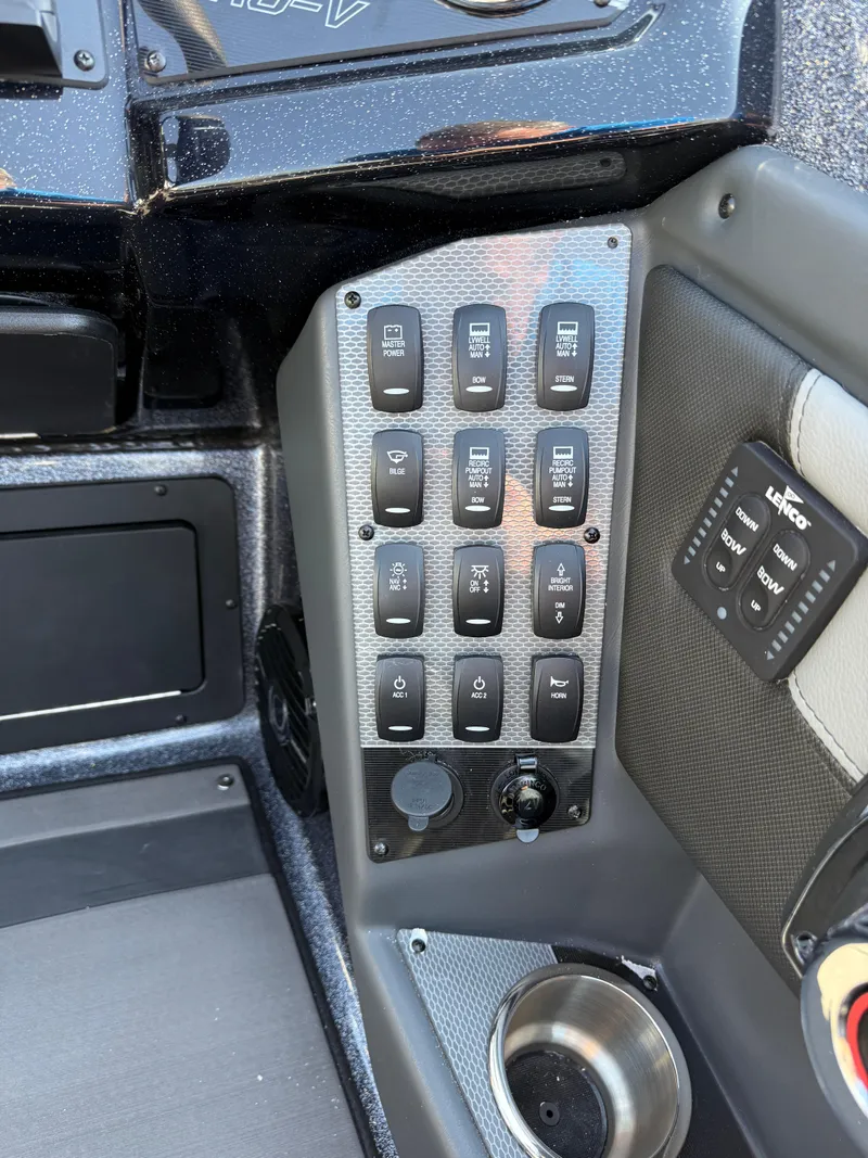 Slide: The Image of Control panel of 2025 Lund 202 Pro-V GL boat with switches and cup holder. - 19