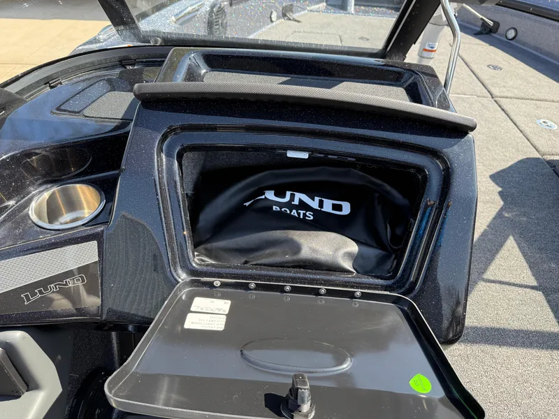 Slide: The Image of 2025 Lund 202 Pro-V GL boat dashboard with storage compartment open. - 23