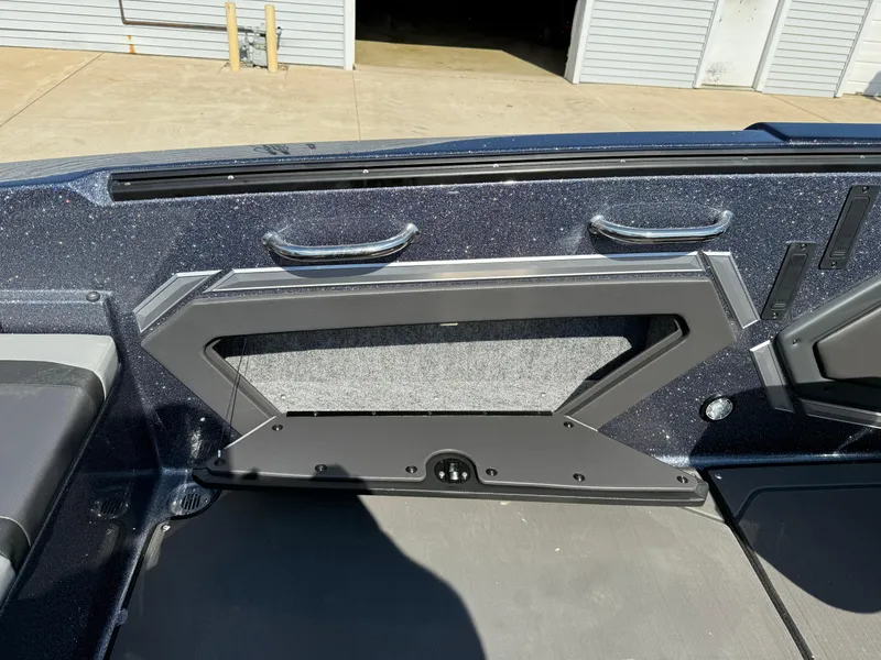 Slide: The Image of 2025 Lund 202 Pro-V GL boat interior with sleek storage compartment and metallic finish. - 26