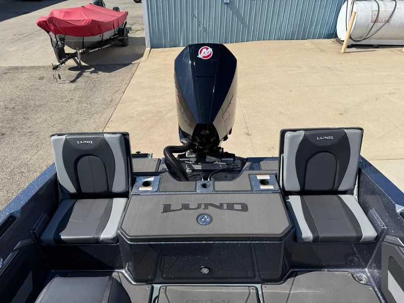 Slide: The Image of 2025 Lund 202 Pro-V GL boat with motor, rear seating, and storage compartments. - 28