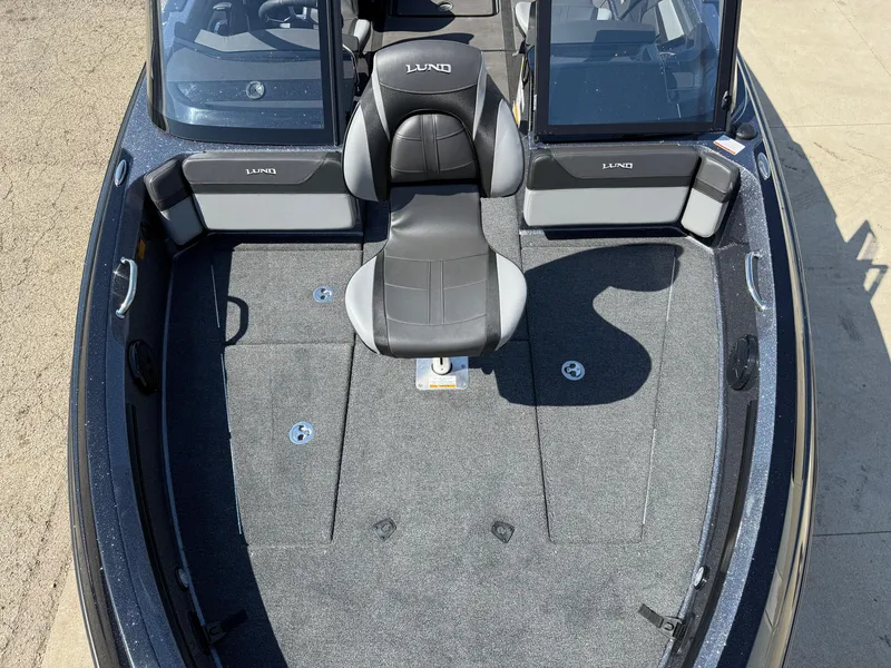Slide: The Image of 2025 Lund 202 Pro-V GL boat interior with seating and carpeted deck. - 5