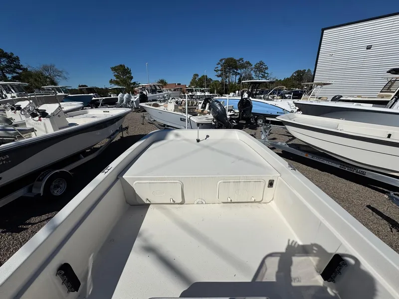 Slide: The Image of 2025 Carolina Skiff E21 DLX CC boat displayed among other boats in a dealership lot. - 5