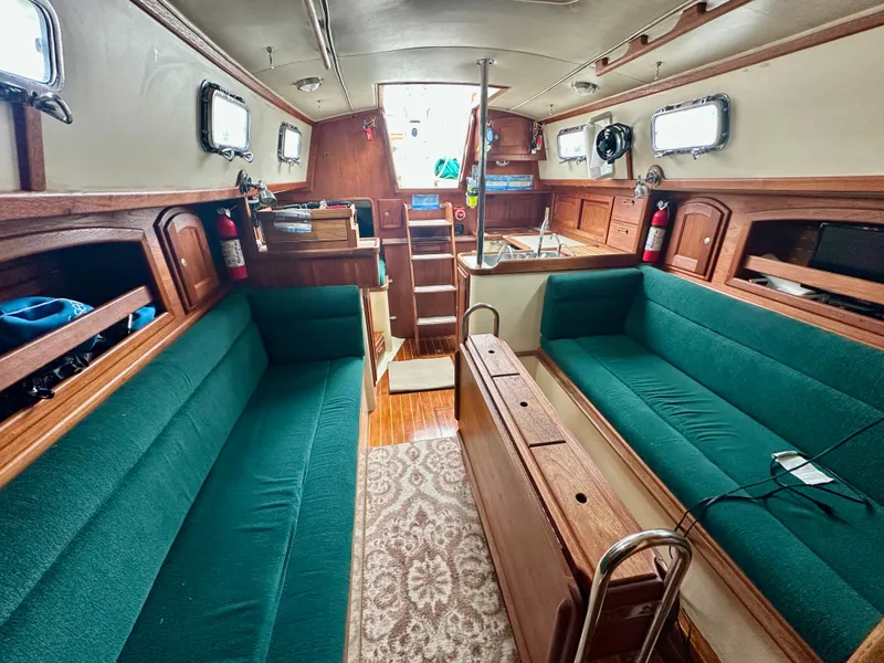 Slide: The Image of Interior of 1998 Pacific Seacraft Cutter with green seating and wooden finishes. - 12