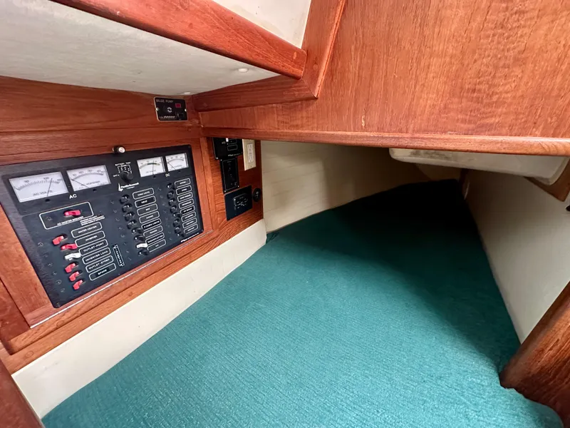 Slide: The Image of 1998 Pacific Seacraft Cutter interior with control panel and green carpet. - 14