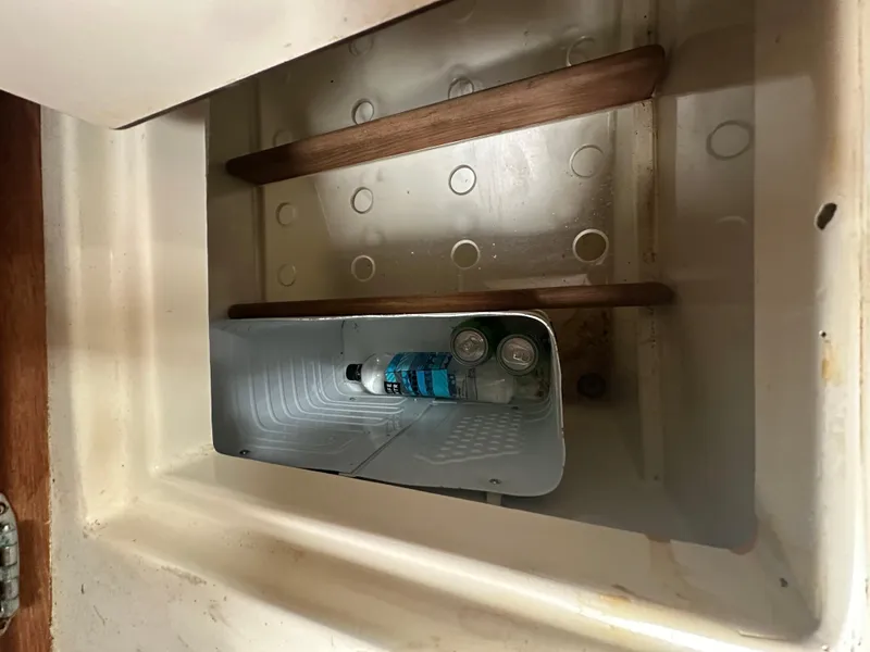 Slide: The Image of Storage compartment in a 1998 Pacific Seacraft Cutter with drinks inside. - 19