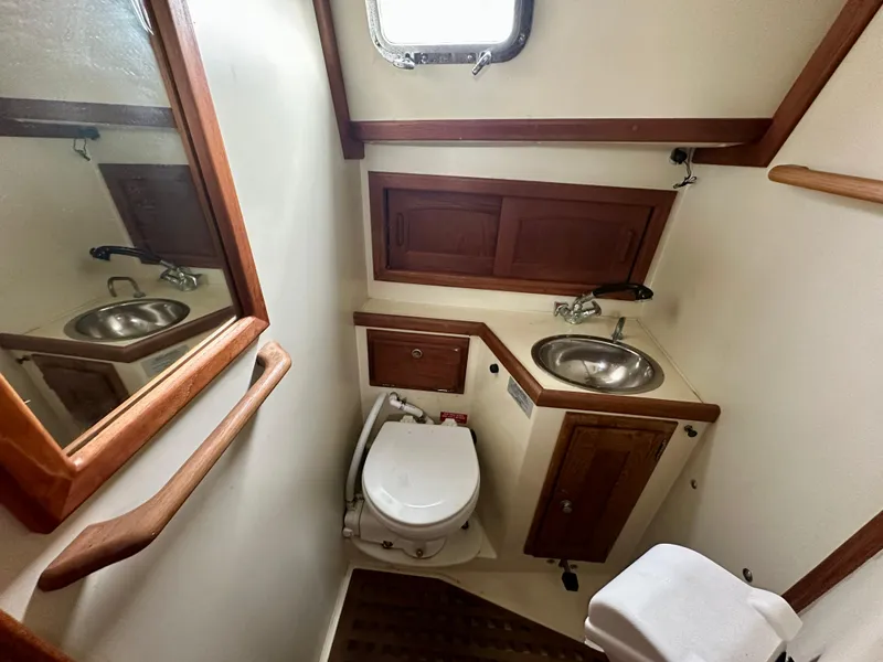 Slide: The Image of 1998 Pacific Seacraft Cutter bathroom with sink, toilet, and wooden cabinetry. - 20