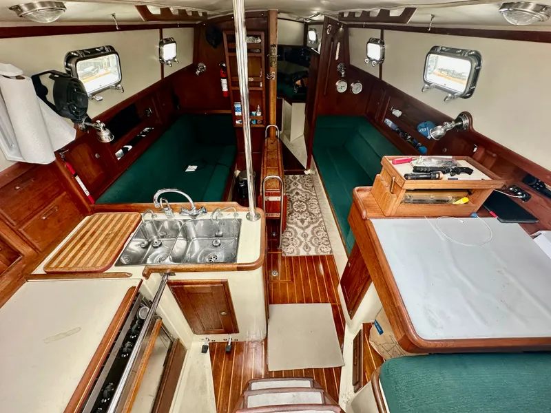 Slide: The Image of Interior of 1998 Pacific Seacraft Cutter sailboat with wood finish and green seating. - 9