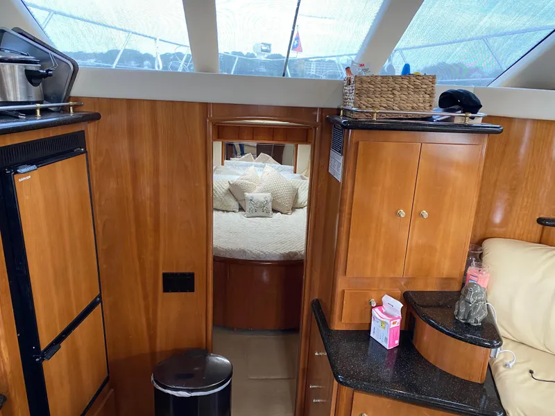 Slide: The Image of Interior of 2002 Carver 444 Cockpit Motor Yacht with wood cabinetry and cozy bedroom. - 18