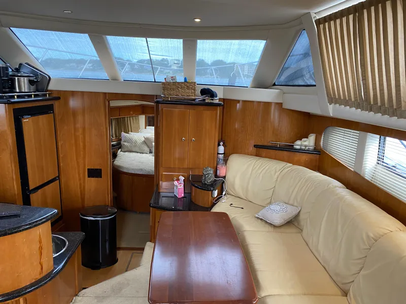 Slide: The Image of Interior of 2002 Carver 444 Cockpit Motor Yacht with cozy seating and wooden cabinetry. - 19