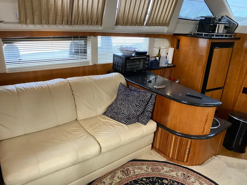Slide: The Image of Interior of 2002 Carver 444 Cockpit Motor Yacht with beige sofa and wooden cabinetry. - 20