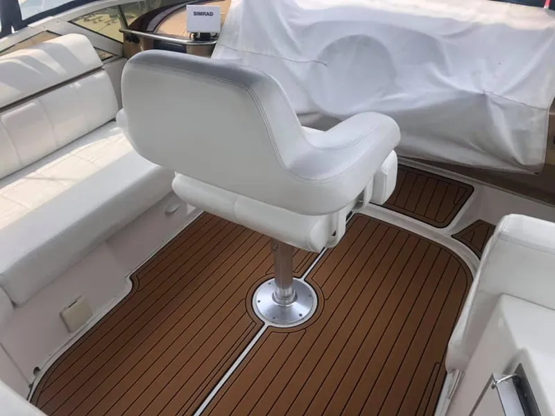 Slide: The Image of 2002 Carver 444 Cockpit Motor Yacht interior with white seating and wood flooring. - 6