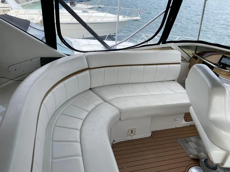 Slide: The Image of 2002 Carver 444 Cockpit Motor Yacht interior with white seating and wood flooring. - 8