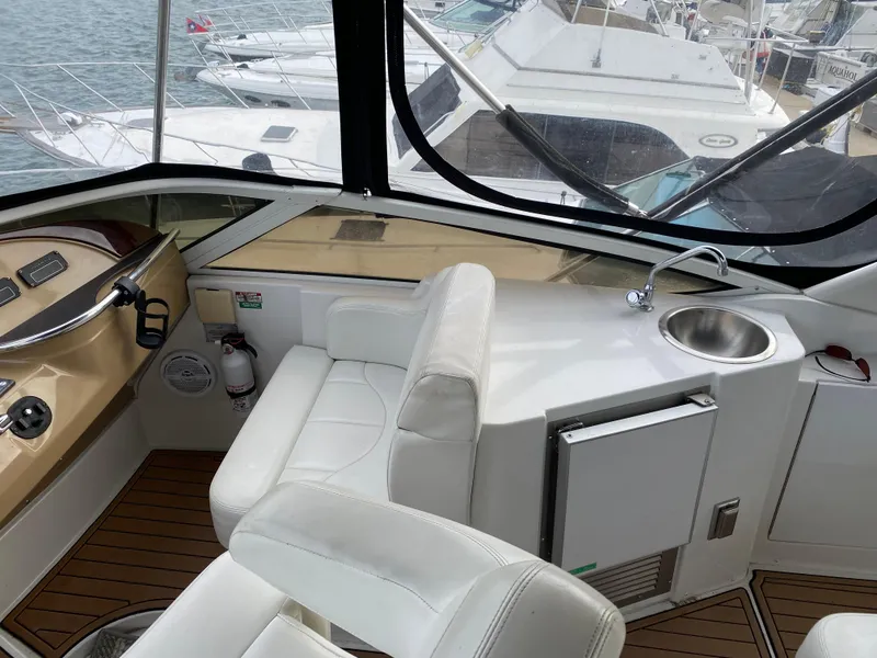 Slide: The Image of Interior of 2002 Carver 444 Cockpit Motor Yacht with helm, seating, and kitchenette. - 9