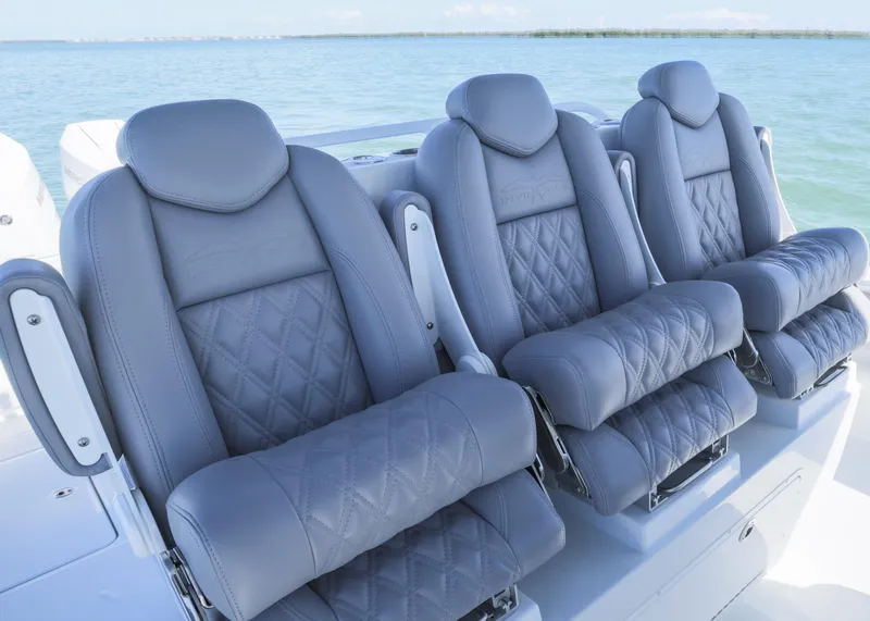 Slide: The Image of 2025 Invincible 39 Open Fisherman boat seats with diamond stitching, ocean backdrop. - 14
