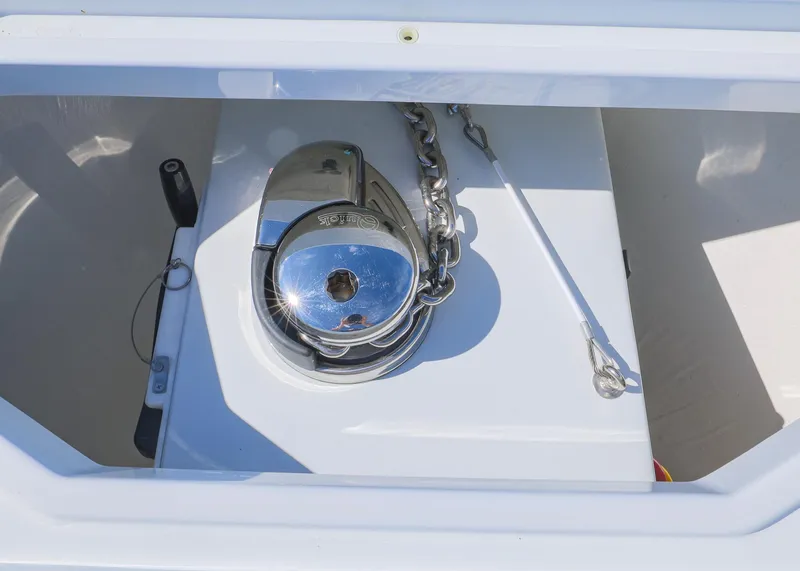 Slide: The Image of Anchor compartment of 2025 Invincible 39 Open Fisherman boat, featuring a shiny metal winch. - 42