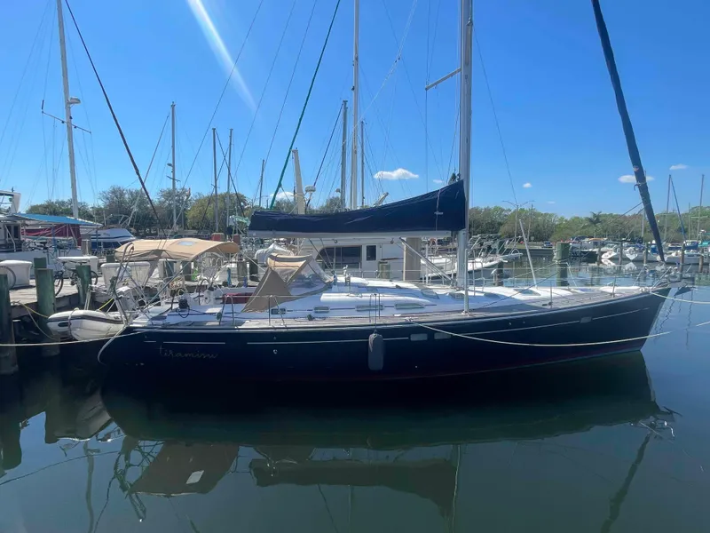 Slide: The Image of 2004 Beneteau Oceanis 473 sailboat docked in a marina under clear blue skies. - 0