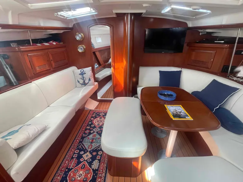 Slide: The Image of Interior of 2004 Beneteau Oceanis 473 yacht with elegant seating and wooden finishes. - 12
