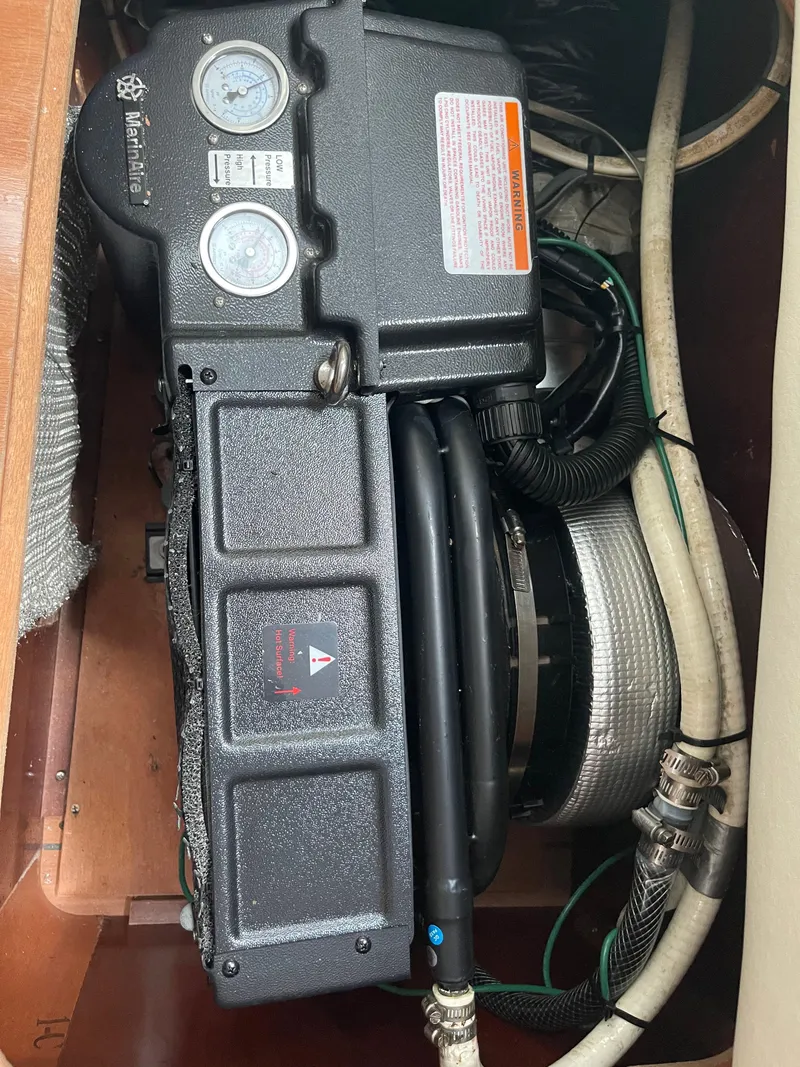 Slide: The Image of Engine compartment of a 2004 Beneteau Oceanis 473 sailboat, showing gauges and hoses. - 14