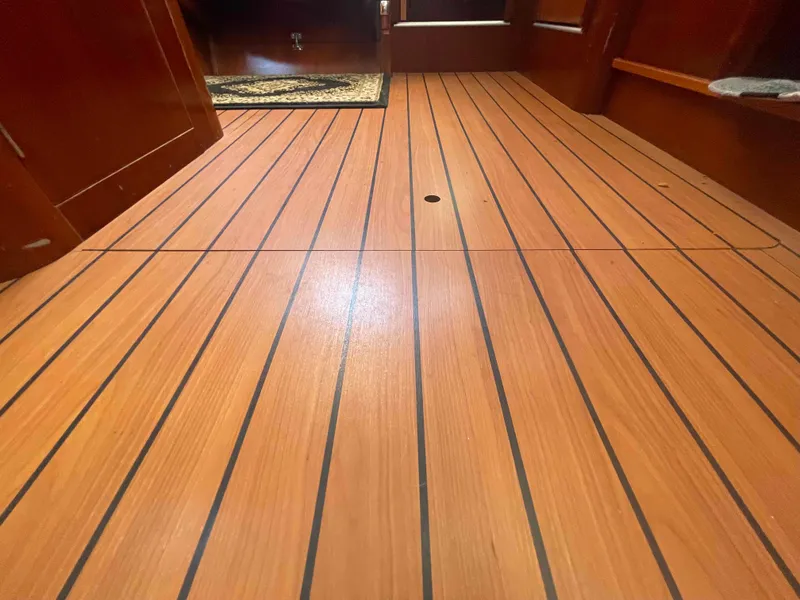 Slide: The Image of Teak flooring inside a 2004 Beneteau Oceanis 473 sailboat cabin. - 19