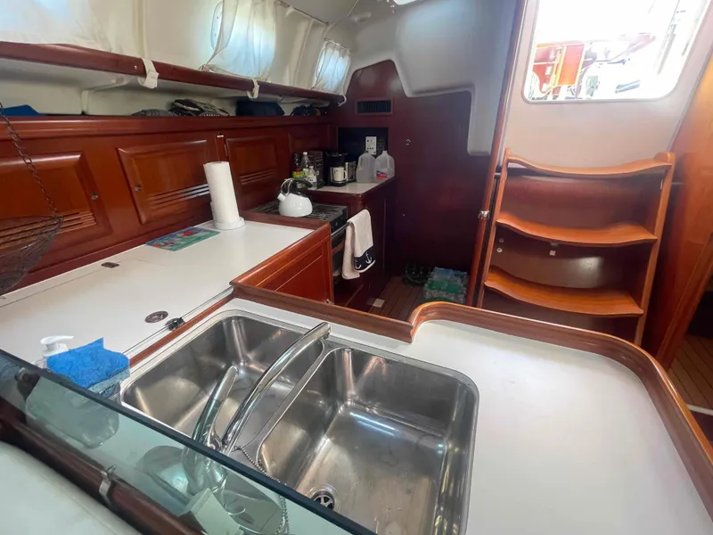 Slide: The Image of Interior of 2004 Beneteau Oceanis 473 yacht, featuring a well-equipped kitchen area. - 24